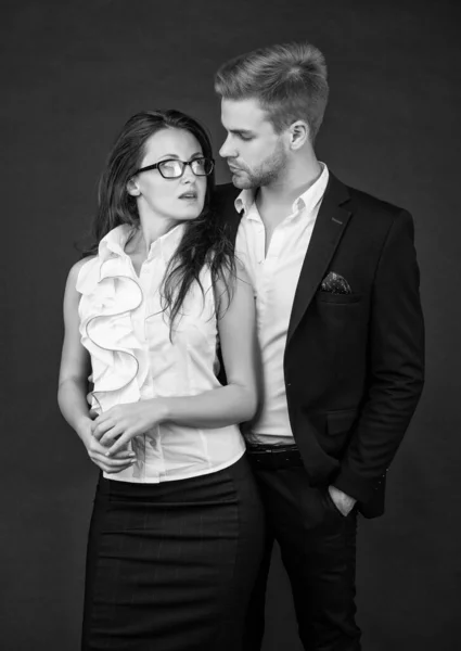 formal couple in love. businessman and businesswoman. partnership of businesspeople. boss and employee. young colleague experts. man and woman in glasses. business partners on black background.