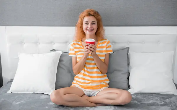 glad woman with morning coffee in bed. good morning. woman with coffee cup. woman hold coffee in the morning.