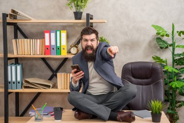 Bu başarıdır. Heyecanlı iş adamı masanın üzerinde bacak bacak üstüne atarak oturuyor. İş başarısı. Heyecandan çığlık atıyordu. Akıllı telefondan iyi haberlerim var..