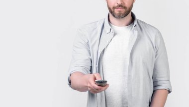 Uzaktan kumandalı insan görüntüsü stüdyo arka planında izole edildi. Stüdyoda uzaktan kumandaya tıklayın. Uzaktan kumandaya tıklayın. insan görüntüsü televizyon kumandası.
