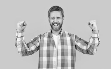 Gündelik giyinen beyaz bir adam. Sarı arka planda, günlük gömlekli, sakallı, beyaz bir adam. Stüdyoda sıradan bir beyaz adam var. Beyaz adamın fotoğrafı. Kareli gömlek giy..