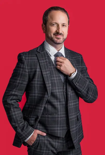 photo of smiling man in business suit. mature man in business suit isolated on red background. business man wear suit in studio. business man wearing suit.