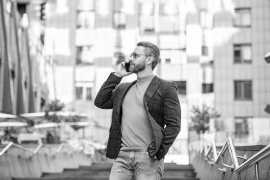 Dışarıdaki cep telefonundan arayan bir adam. Cep telefonundan arayan bir adamın görüntüsü. Adamın dışarıda cep telefonu görüşmesi var. Sokakta cep telefonu arayan bir adam var..