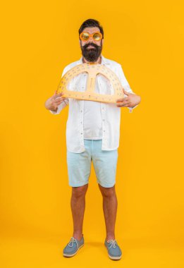 Stüdyoda geometri açıölçeri olan bir adam var. Adam arka planda geometri açıölçer tutuyor. İnsan tutuşu geometri iletkeninin fotoğrafı. Geometri açıölçer tutan adam sarıda izole edilmiş..