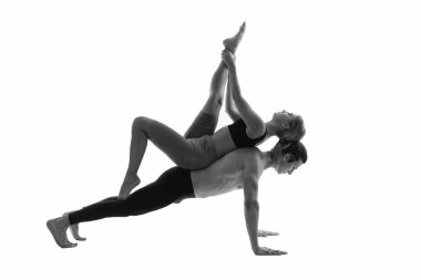 Spor yoga çiftlerinin birlikte antrenman fotoğrafları. Beyaz arka planda izole edilmiş yoga çifti. Spor yoga çifti stüdyoda. Arka planda spor yoga çifti.