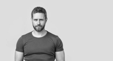 Stüdyoda sakallı, fotokopi odası olan beyaz bir adam. Sakallı beyaz bir adamın fotoğrafı. Kirli sakallı beyaz adam tişört giyiyor. Gri arka planda sakallı beyaz adam izole edilmiş..