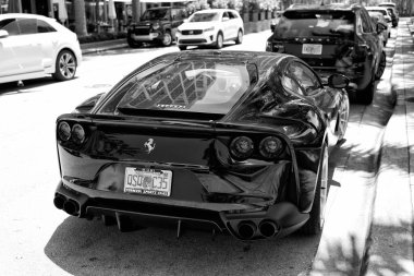 Miami Beach, Florida USA - April 15, 2021: black ferrari F12 berlinetta supercar, side back view.
