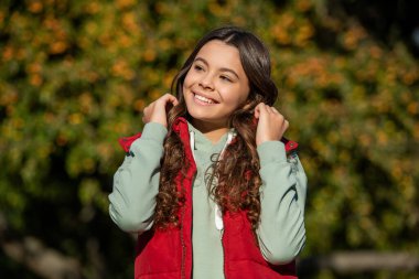 Genç kıvırcık kız portresi dışarıda. Güneşli bir günde genç kız portresi. Kıvırcık bir genç kızın portresi. Açık havada genç kız portresi.