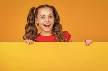 Reklam için fotokopi alanı olan boş sarı kağıdın arkasındaki çocuk hayrete düştü..