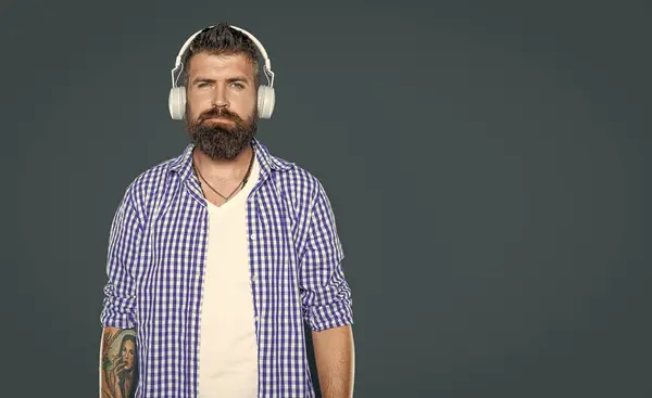 bearded guy listen to music in headphones.