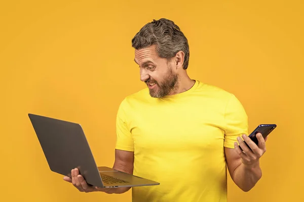angry man assistant has call on background. man assistant has call in studio. photo of man assistant has call with laptop. man assistant has call isolated on yellow.