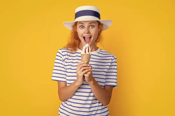 summer woman eat sweet cone in studio. summer woman with sweet cone on background. photo of summer woman with sweet cone in retro hat. summer woman with sweet cone isolated on yellow.