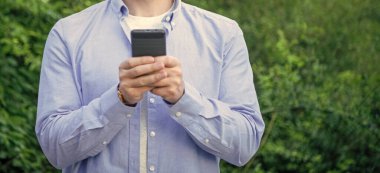 Adam telefondaki mesajları kontrol ediyor, e-postaları kontrol ediyor, uzay afişini kopyalıyor. Telefonda mesajlaşan bir adamın fotoğrafı. Adam telefonda mesajlaşıyor. Adam dışarıda telefonla mesajlaşıyor..