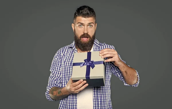 stock image surprised mature bearded guy with present box on grey background.