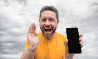 Afallamış bir adam akıllı telefon ekranını kopyalama alanı ile sunuyor.