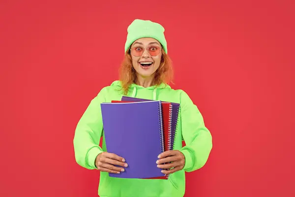school education of amazed woman student. school woman student isolated on red background. school woman student at studio. photo of school woman student hold books.