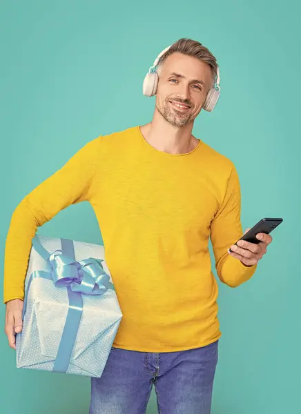cheerful shopping man buy online in studio. shopping man buy online on background. photo of shopping man buy online. shopping man buy online isolated on blue.