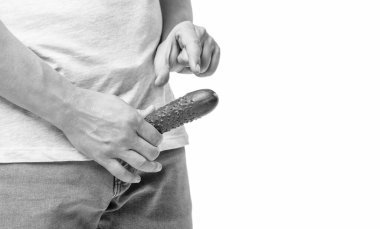 Man crop view showing small size gesture holding cucumber as penis at crotch level isolated on white, copy space.