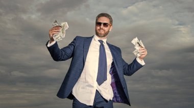 Para banknotlu milyonerin fotoğrafı. Gökyüzü geçmişinde parası olan milyoner bir adam. Parası olan milyoner bir adam. Takım elbiseli milyoner adam..