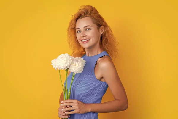 happy woman with spring flowers isolated on yellow. woman with spring flowers in studio. woman with spring flowers on background. photo of woman with spring flowers.