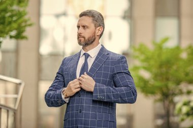 Sokakta ceket giyen şık bir iş adamı. İş patronunun kravatlı fotoğrafı. İş patronu dışarıda. Kentsel altyapıda iş patronu.