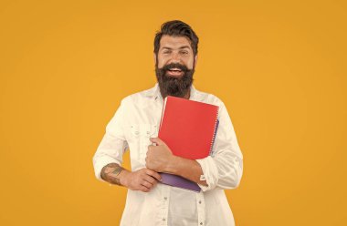 Sırıtkan milenyum adamı planlayıcısı sarıda soyutlanmış. Stüdyoda planlayıcısı olan bin yıllık bir adam. Arkaplanda planlayıcısı olan bin yıllık bir adam. Ajandalı milenyum adamının fotoğrafı..
