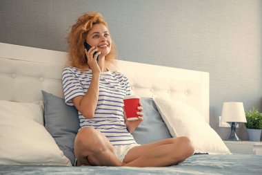 Kahveli kadının telefonla araması güzel. Evdeki kadının telefonu var. Kadının evine telefon var..