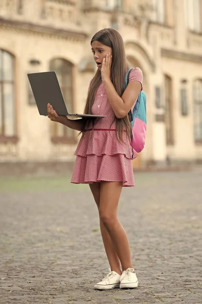 shocked school girl stydy online outdoor. photo of school girl stydy online. school girl stydy online. school girl stydy online with computer.