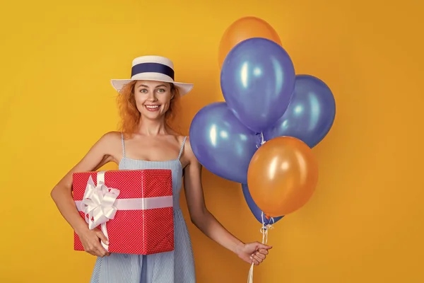 happy birthday woman with present on background. photo of birthday woman with present and balloons. birthday woman with present isolated on yellow. birthday woman with present in studio.