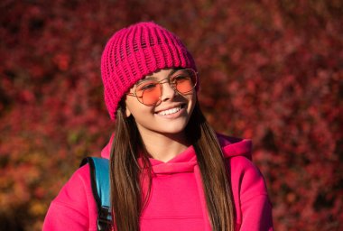 Sonbahar ders çalışma zamanıdır. Bilgi ve eğitim. Okul eğitimi. Okula dönüyorum. Okul çantası taşıyan sonbahar kızı. Ergenlik için eğitim. Sonbahar parkındaki genç kız. Mutlu yüz..