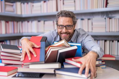 Kütüphanede kitap seven bir adam. Sınıfta öğretmen beyin fırtınası yapıyor. Öğretmen için bilgi günü. Okul eğitimi ve bilgisi. Derste ya da sınavda kitap kurdu öğretmeni. Başarı için temel.