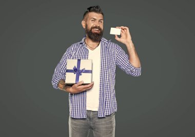 Kartı ve ambalajı olan olgun sakallı bir adam. çevrimiçi alışveriş kavramı