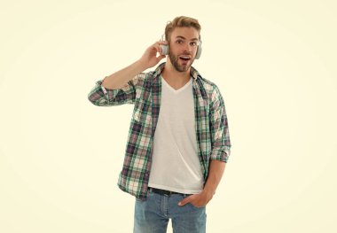 Hayret bir adam müzik dinler. Beyazların izole edilmiş müziğini dinle. Adam arka planda müzik dinliyor. Stüdyoda müzik dinle..