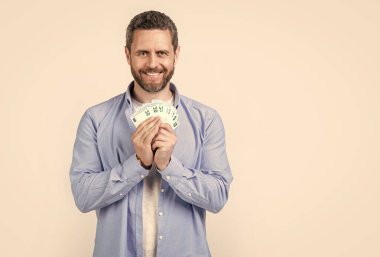 Maaş parası olan bir adam stüdyo arka planında fotokopi alanı ile izole edilmiş. Stüdyoda maaşı olan bir adam. Maaşlı banknotları olan bir adam. maaş parası