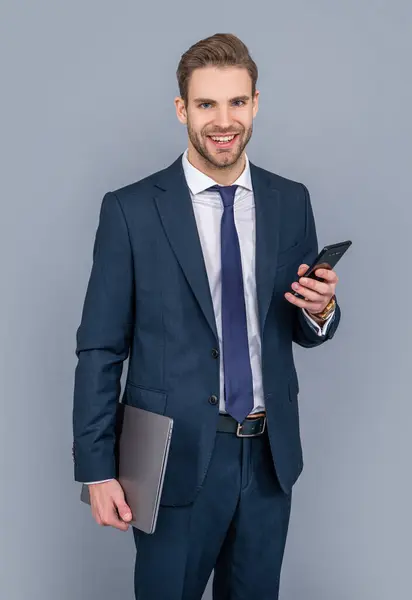 Young business man with phone. Business communication. Casual business man chatting on phone isolated on grey. Businessman using phone. Man phone conversation in studio. good news.