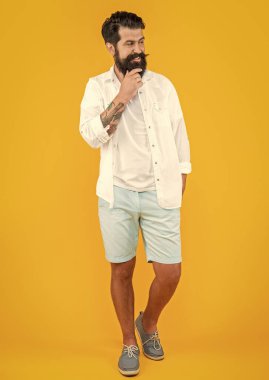 Arka planda mutlu stil adamı. Sakallı şık bir adamın fotoğrafı. Sarıda izole edilmiş şık bir adam. Stüdyoda şık bir adam.