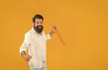 Kızgın adam stüdyoda kopya uzay pankartıyla okul yönetimini elinde tutuyor. Arka planda okulun yöneticisi var. Okul hükümdarının fotoğrafı. Okulun hükümdarı sarı üzerine izole edilmiş..