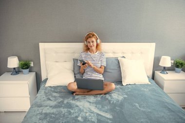 Telefondaki kadın sohbeti. Kadın evde telefonla konuşurken gülümsüyor. Kulaklıklı kadının telefon görüşmesi..