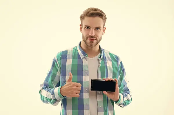 man shows phone screen in studio, thumb up. man showing phone screen on background. photo of man presenting phone screen. man with phone screen isolated on white.