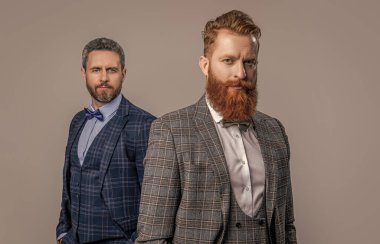 Stüdyoda smokinli erkeklerin seçici odak noktası. Smokinli erkekler arka planda. Smokin giymiş erkek giyimli erkeklerin fotoğrafı. Erkekler smokin giyer, erkekler gri giyinir..