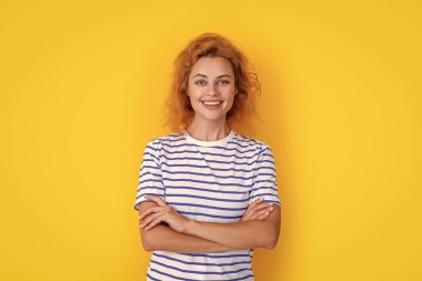 Sarı arka planda izole edilmiş kızıl saçlı kadın portresi. Stüdyoda gülümseyen kızıl saçlı genç kadının portresi. Yetişkin kızıl kadın portresi.