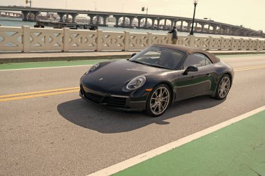Miami, Florida ABD - 15 Nisan 2021 Porsche 911 Carrera yolda, köşe manzaralı.