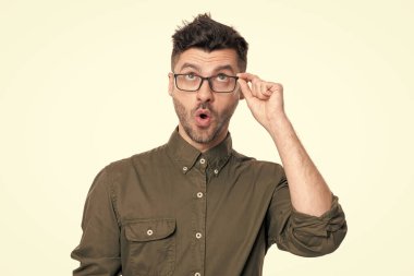 Beyaz arka planda izole edilmiş şok olmuş bir adamın portresi. Stüdyoda çalışan adam portresi. Gözlüklü bir çalışan. Yetişkin işçi gömleği giyer..