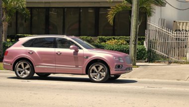 Miami Beach, Florida USA - April 15, 2021: pink Bentley Bentayga v8 2015 modern suv, front side view.