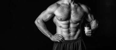 Steroidli kaslı vücut geliştirici, kopyalama alanı. Steroid kavanozlu kaslı vücut geliştirici. Steroid haplı kaslı vücut geliştiricinin fotoğrafı. Siyah steroidli kaslı vücut geliştirici..