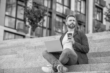 Sokaktaki serbest çalışan adam, Banner. Dışarıda polisle serbest çalışan bir adam. Bilgisayarlı serbest çalışan adamın fotoğrafı. Dışarıda dizüstü bilgisayarı olan serbest çalışan bir adam..