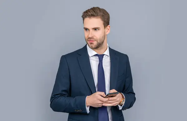 Businessman using phone. Man phone conversation in studio. Young business man with phone. Business communication. Casual business man chatting on phone isolated on grey. leaving voice message.