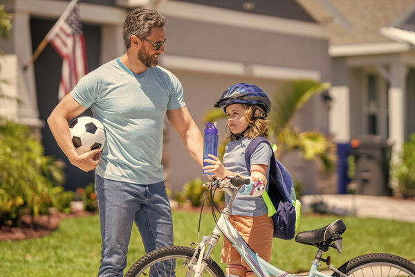 Папа и сын вместе развивают свое детство на велосипеде под открытым небом.