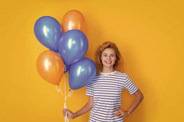 stock image positive woman hold party balloons in studio. woman with balloon for party isolated on yellow background. party woman with balloon.