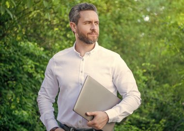 Kafkasyalı iş adamının fotoğrafı bilgisayarda açık havada internet işi yapıyor..